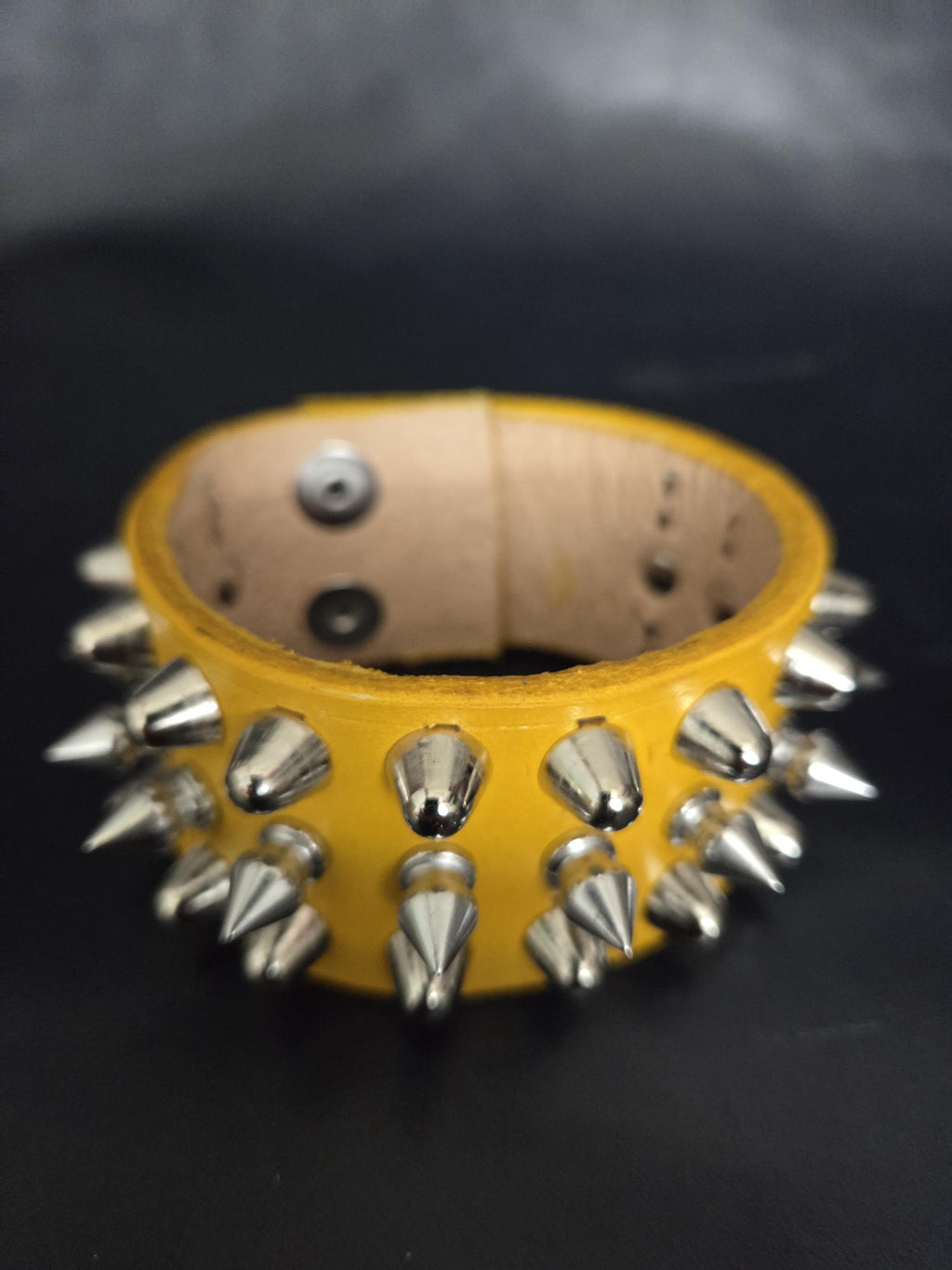 Spiked yellow leather wrist cuff.