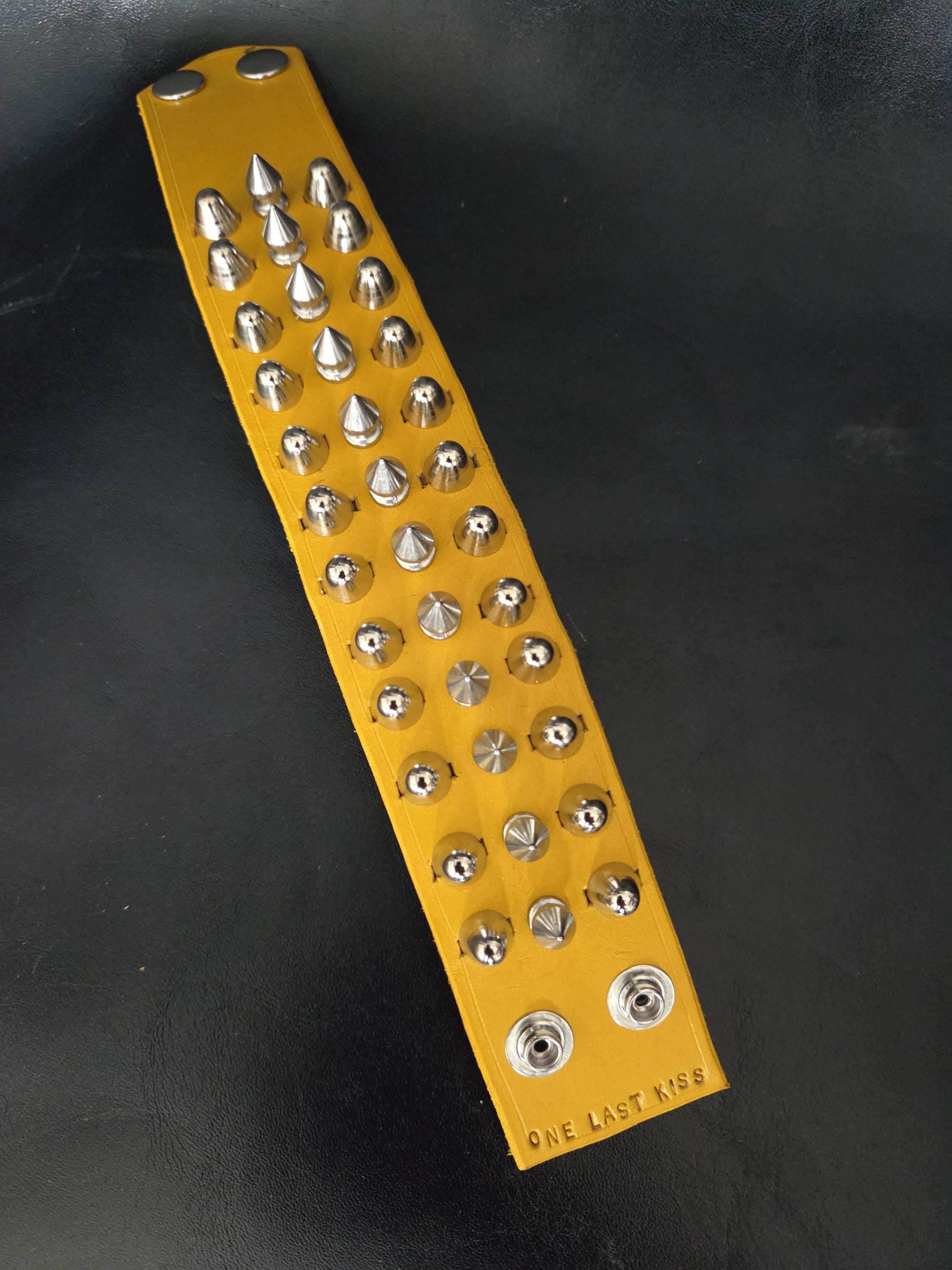 Spiked yellow leather wrist cuff.